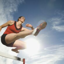 Female athlete jumping hurdle, Utah, United States